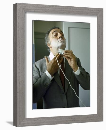 Director Federico Fellini with Powder on His Face as He Shaves with an Electric Shaver-Carlo Bavagnoli-Framed Photographic Print