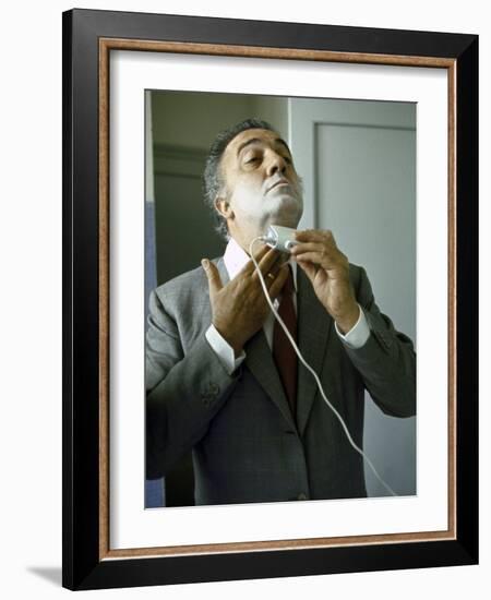 Director Federico Fellini with Powder on His Face as He Shaves with an Electric Shaver-Carlo Bavagnoli-Framed Photographic Print