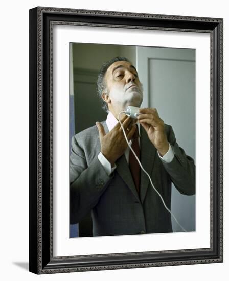 Director Federico Fellini with Powder on His Face as He Shaves with an Electric Shaver-Carlo Bavagnoli-Framed Photographic Print