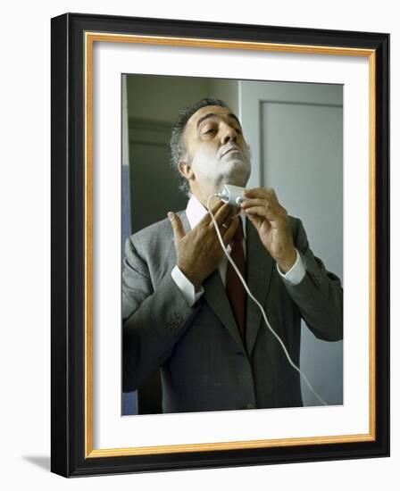 Director Federico Fellini with Powder on His Face as He Shaves with an Electric Shaver-Carlo Bavagnoli-Framed Photographic Print