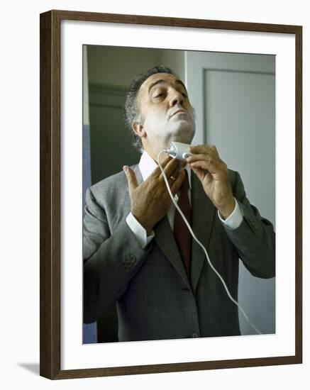 Director Federico Fellini with Powder on His Face as He Shaves with an Electric Shaver-Carlo Bavagnoli-Framed Photographic Print