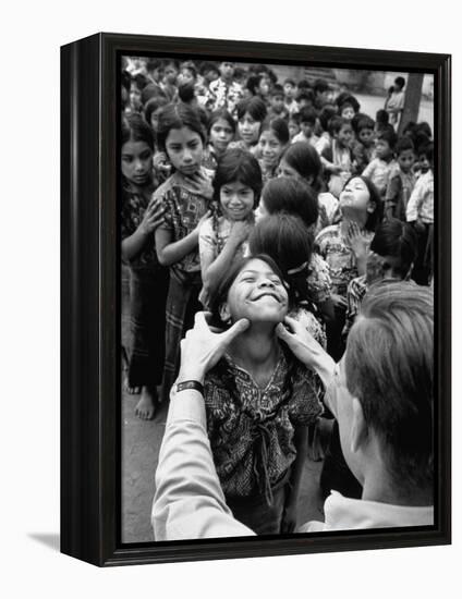 Dr. Nevin S. Scrimshaw of the Central American Institute of Nutrition Examining Children for Goiter-Cornell Capa-Framed Premier Image Canvas