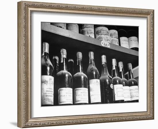 Dust-Covered Wine and Brandy Bottles Standing on Racks in a Wine Cellar-null-Framed Photographic Print