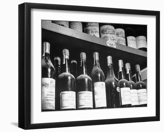 Dust-Covered Wine and Brandy Bottles Standing on Racks in a Wine Cellar--Framed Photographic Print