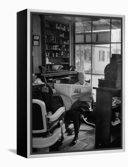 Elderly Barber Sitting Reading the Morning Paper in Small Village Shop in Small New England Town-Yale Joel-Framed Premier Image Canvas