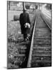 Elderly Hobo, with Bundle Strapped to His Back, Walking Along Train Tracks-Carl Mydans-Mounted Photographic Print