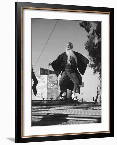 Elderly Japanese Movie Extra Jumping on Trampoline-Ralph Crane-Framed Photographic Print