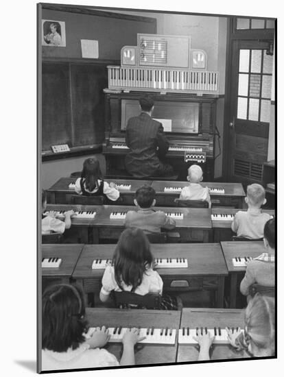 Elementary School Music Teacher Playing F-Major Chord on Piano, Keys Light up on Plastic Keyboard-Yale Joel-Mounted Photographic Print