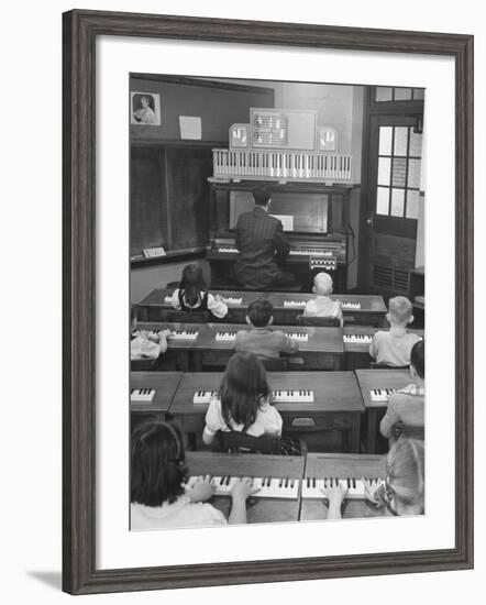 Elementary School Music Teacher Playing F-Major Chord on Piano, Keys Light up on Plastic Keyboard-Yale Joel-Framed Photographic Print