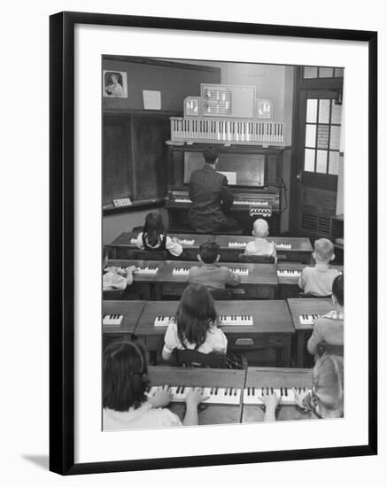 Elementary School Music Teacher Playing F-Major Chord on Piano, Keys Light up on Plastic Keyboard-Yale Joel-Framed Photographic Print