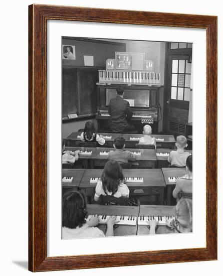 Elementary School Music Teacher Playing F-Major Chord on Piano, Keys Light up on Plastic Keyboard-Yale Joel-Framed Photographic Print