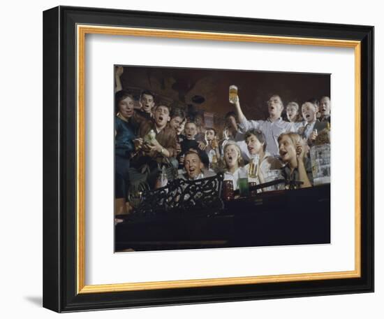 Elevated View of a Group of People as They Sing Along with a Pianist in a Unidentified Bar, 1959-Yale Joel-Framed Photographic Print