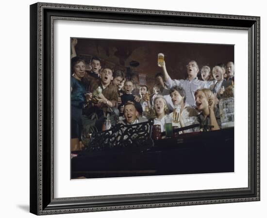 Elevated View of a Group of People as They Sing Along with a Pianist in a Unidentified Bar, 1959-Yale Joel-Framed Photographic Print