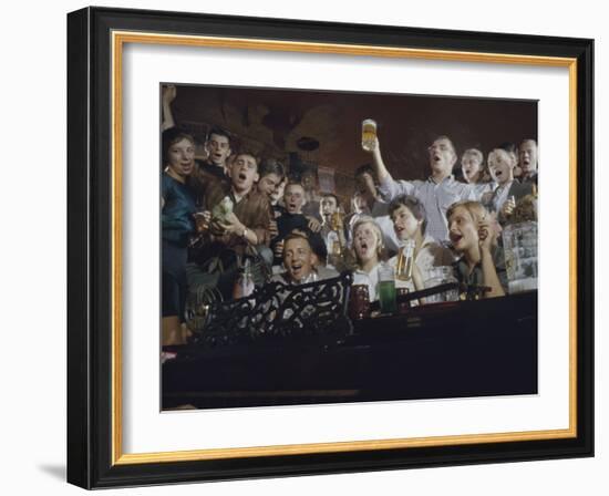 Elevated View of a Group of People as They Sing Along with a Pianist in a Unidentified Bar, 1959-Yale Joel-Framed Photographic Print