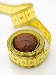 Chocolate Truffle Lying in Rolled-Up Tape Measure-Elisabeth Cölfen-Photographic Print