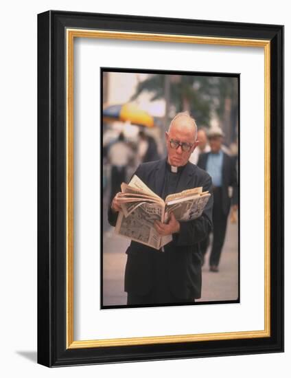 Episcopalian Priest Reading a Newspaper While Walking in Street, New York City-Vernon Merritt III-Framed Photographic Print