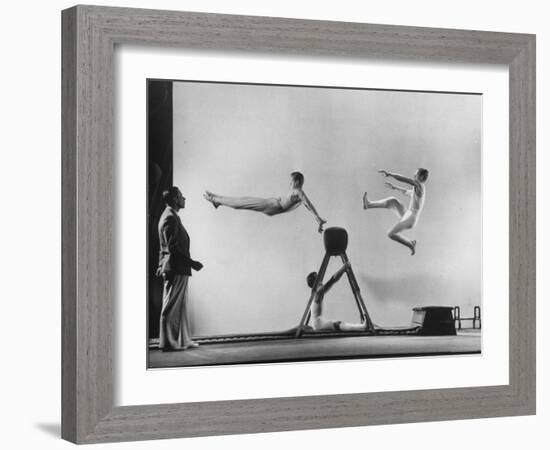 Erik Flensted Jensen, Coach of Danish Gymnastic Team, Watching as Three Men Perform-Gjon Mili-Framed Photographic Print