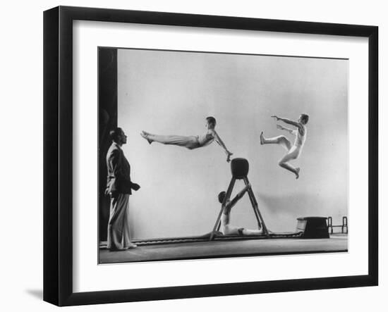 Erik Flensted Jensen, Coach of Danish Gymnastic Team, Watching as Three Men Perform-Gjon Mili-Framed Photographic Print