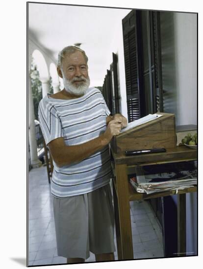 Ernest Hemingway at the Standing Desk on the Balcony of Bill Davis's Home Near Malaga-Loomis Dean-Mounted Premium Photographic Print