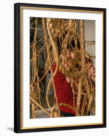 Eva Hesse Peering Through Her Sculpture of Rubber Dipped String and Rope-Henry Groskinsky-Framed Premium Photographic Print