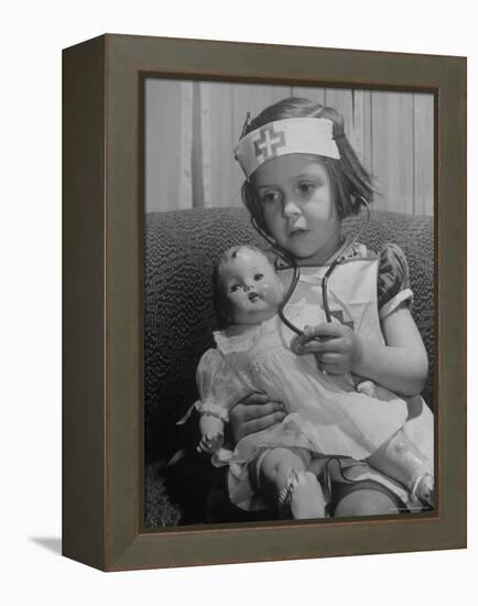 Evelyn Mott playing Nurse with doll as parents adjust children to abnormal conditions in wartime-Alfred Eisenstaedt-Framed Premier Image Canvas