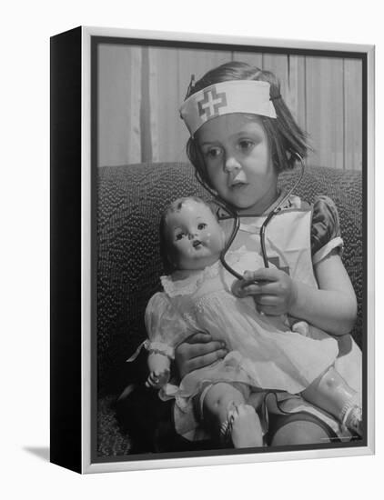 Evelyn Mott playing Nurse with doll as parents adjust children to abnormal conditions in wartime-Alfred Eisenstaedt-Framed Premier Image Canvas