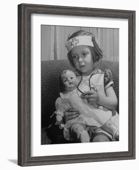 Evelyn Mott playing Nurse with doll as parents adjust children to abnormal conditions in wartime-Alfred Eisenstaedt-Framed Photographic Print