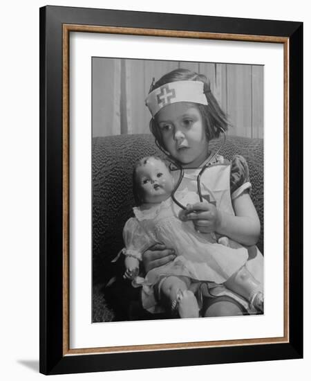 Evelyn Mott playing Nurse with doll as parents adjust children to abnormal conditions in wartime-Alfred Eisenstaedt-Framed Photographic Print