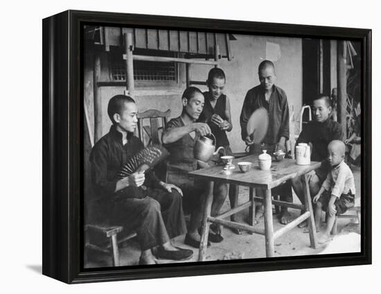 Family Having Tea in Courtyard-Carl Mydans-Framed Premier Image Canvas