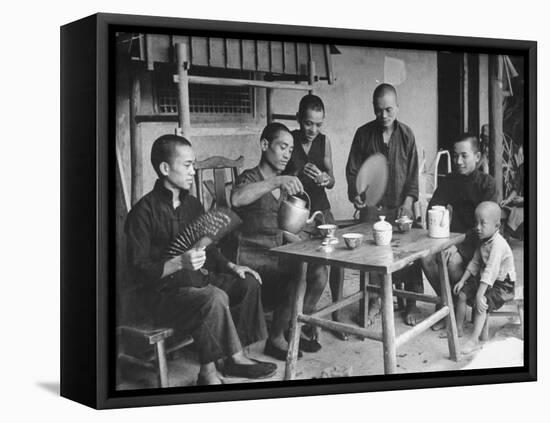 Family Having Tea in Courtyard-Carl Mydans-Framed Premier Image Canvas