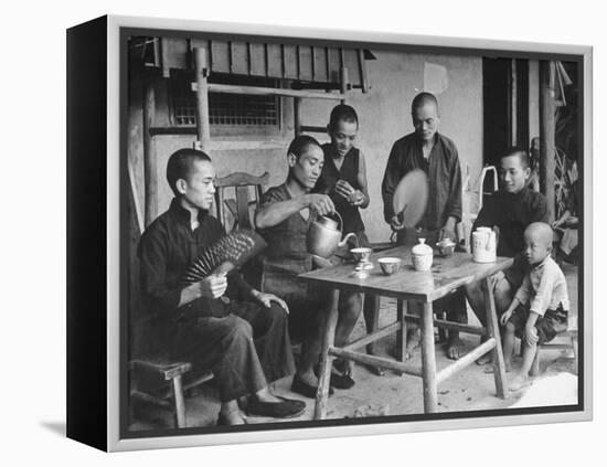 Family Having Tea in Courtyard-Carl Mydans-Framed Premier Image Canvas