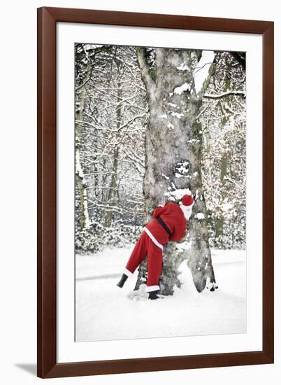 Father Christmas in Snow Behind Tree-null-Framed Photographic Print