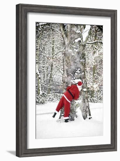 Father Christmas in Snow Behind Tree-null-Framed Photographic Print