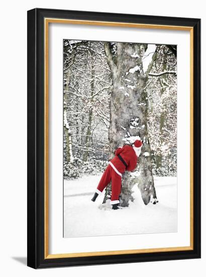 Father Christmas in Snow Behind Tree-null-Framed Photographic Print