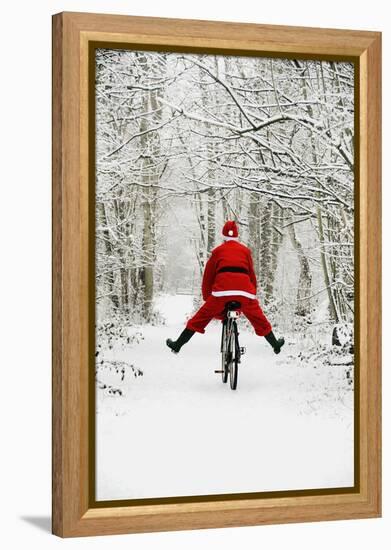 Father Christmas Riding Bicycle in Snowy Woodland Path-null-Framed Premier Image Canvas
