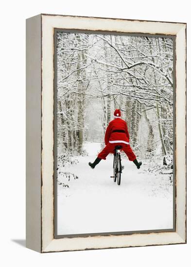 Father Christmas Riding Bicycle in Snowy Woodland Path-null-Framed Premier Image Canvas