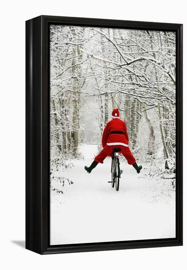 Father Christmas Riding Bicycle in Snowy Woodland Path-null-Framed Premier Image Canvas