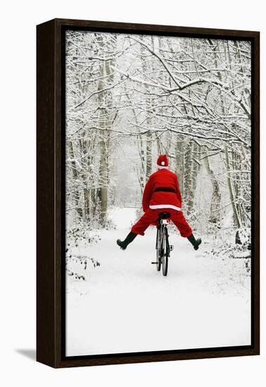 Father Christmas Riding Bicycle in Snowy Woodland Path-null-Framed Premier Image Canvas