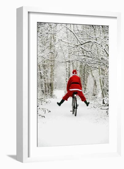Father Christmas Riding Bicycle in Snowy Woodland Path-null-Framed Photographic Print