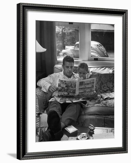 Father Sitting on Couch with Pigtailed Daughter Reading to Her the Sunday Comic Pages-Nina Leen-Framed Photographic Print