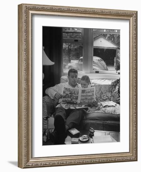 Father Sitting on Couch with Pigtailled Daughter Reading to Her the Sunday Comic Pages-Nina Leen-Framed Photographic Print