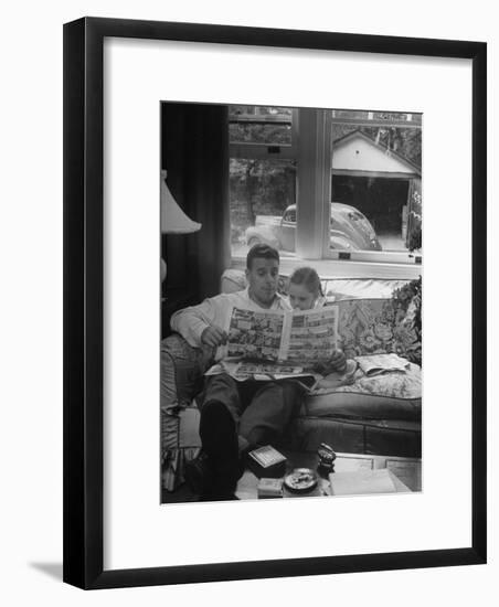 Father Sitting on Couch with Pigtailled Daughter Reading to Her the Sunday Comic Pages-Nina Leen-Framed Photographic Print