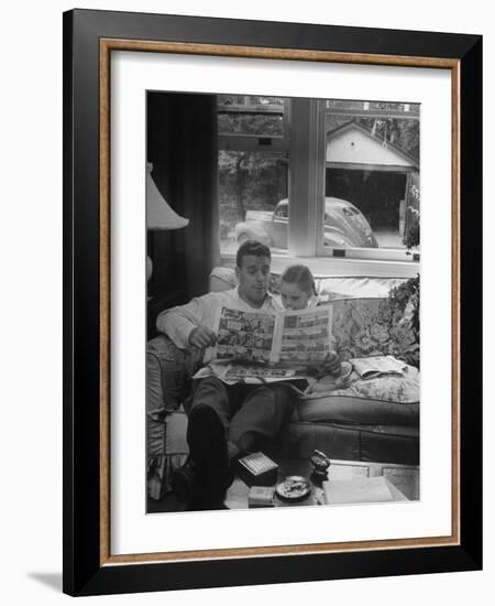 Father Sitting on Couch with Pigtailled Daughter Reading to Her the Sunday Comic Pages-Nina Leen-Framed Photographic Print