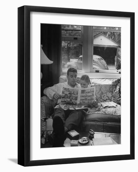 Father Sitting on Couch with Pigtailled Daughter Reading to Her the Sunday Comic Pages-Nina Leen-Framed Photographic Print