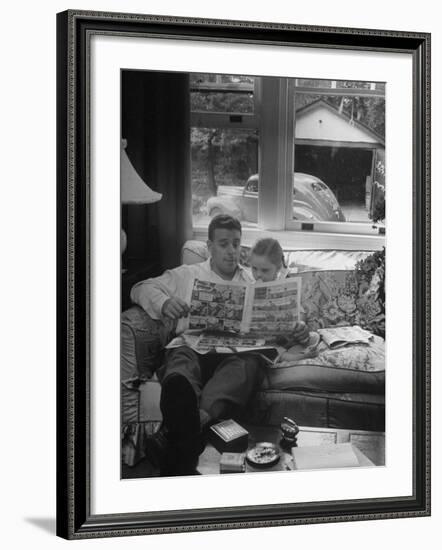 Father Sitting on Couch with Pigtailled Daughter Reading to Her the Sunday Comic Pages-Nina Leen-Framed Photographic Print