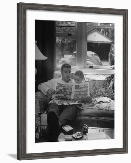 Father Sitting on Couch with Pigtailled Daughter Reading to Her the Sunday Comic Pages-Nina Leen-Framed Photographic Print