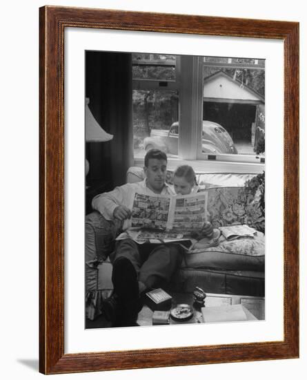 Father Sitting on Couch with Pigtailled Daughter Reading to Her the Sunday Comic Pages-Nina Leen-Framed Photographic Print