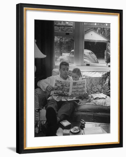 Father Sitting on Couch with Pigtailled Daughter Reading to Her the Sunday Comic Pages-Nina Leen-Framed Photographic Print