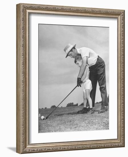 Father Teaching His Small Son How to Play Golf--Framed Photographic Print