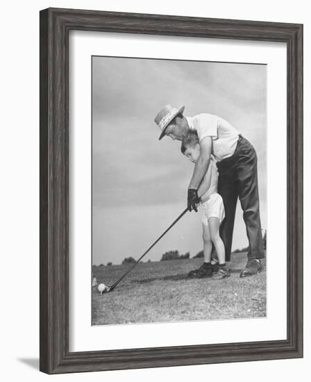 Father Teaching His Small Son How to Play Golf-null-Framed Photographic Print